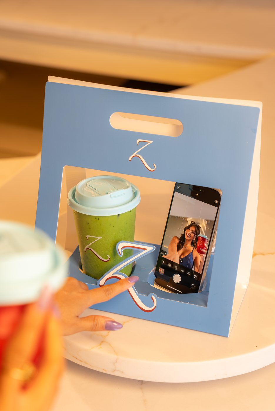 Blue Z carrier bag with a matcha and a phone