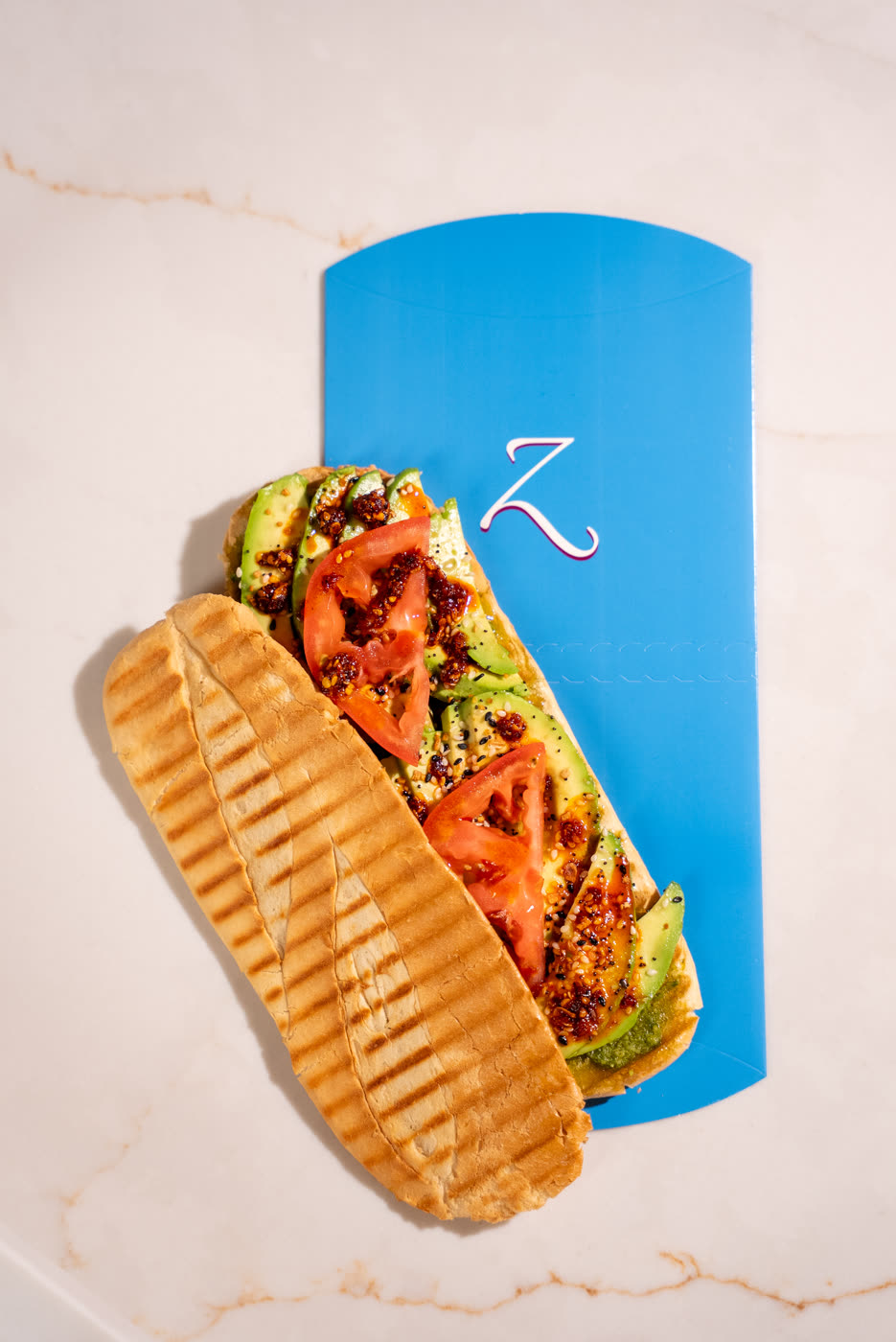 Feedo's Avocado panini with avocado, tomato, everything seasoning and chili oil